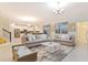Spacious living room with neutral tones, opening to kitchen and dining areas at 481 Ocean Course Ave, Davenport, FL 33896