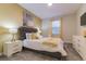 Comfortable main bedroom with stylish bed, artwork, and a window with bright natural light at 481 Ocean Course Ave, Davenport, FL 33896