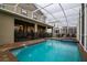 Private screened-in pool and spa area in backyard with patio furniture at 481 Ocean Course Ave, Davenport, FL 33896
