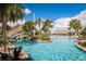 Community pool with a water slide, lush palm trees, and a tiki hut at 481 Ocean Course Ave, Davenport, FL 33896