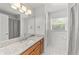Bright bathroom featuring a granite countertop, wood cabinets, and tiled floors, with a window and ample lighting at 4811 Doc Dr, St Cloud, FL 34771