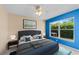 Cozy bedroom with a large window, blue accent wall, and a comfortable bed with decorative pillows at 4811 Doc Dr, St Cloud, FL 34771