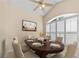 Dining room featuring a ceiling fan, plantation shutters on an arched window, and a wood table with set plates at 4811 Doc Dr, St Cloud, FL 34771
