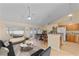Well-lit living room featuring an eat-in kitchen with wooden cabinets, modern decor, and light wood flooring at 4811 Doc Dr, St Cloud, FL 34771