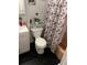 Compact bathroom with a toilet, shower, and vanity, decorated with a black-and-red Paris-themed shower curtain at 4834 Ute St, Orlando, FL 32819