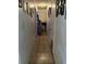 Narrow hallway with tile floors and gallery wall featuring Gathering photos, leading to other rooms at 4834 Ute St, Orlando, FL 32819
