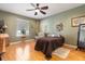 Cozy bedroom with wood floors, a fan, a comfortable bed and natural light from the window at 4911 Lazy Oaks Way, St Cloud, FL 34771