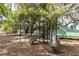 Community playground with swings and slides under mature shade trees, perfect for children at 4911 Lazy Oaks Way, St Cloud, FL 34771