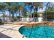 Inviting screened-in pool area featuring a waterfall feature and lush tropical landscaping at 4911 Lazy Oaks Way, St Cloud, FL 34771