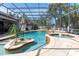 Stunning pool area with island, spa, and rock features surrounded by lush tropical greenery at 4911 Lazy Oaks Way, St Cloud, FL 34771