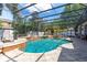 Inviting screened-in pool area featuring a waterfall feature and lush tropical landscaping at 4911 Lazy Oaks Way, St Cloud, FL 34771