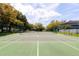 Well-maintained community tennis court surrounded by mature trees, perfect for recreation at 4911 Lazy Oaks Way, St Cloud, FL 34771