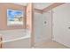 A bathroom features a tub and a shower with white tiles, all illuminated by a window at 50 Sawfish Ct, Kissimmee, FL 34759