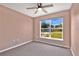 This bedroom is well-lit from a window with a ceiling fan and plush carpet at 50 Sawfish Ct, Kissimmee, FL 34759