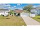 Well maintained one story home with green siding, brick accents, and a two car garage at 50 Sawfish Ct, Kissimmee, FL 34759