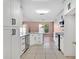 Well lit kitchen area with stainless steel appliances, white cabinetry, tile flooring and eat-in bar at 50 Sawfish Ct, Kissimmee, FL 34759