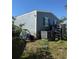 Back of home featuring vinyl siding, blue shutters, and well-maintained AC unit and storage shed at 50989 Highway 27 # 210, Davenport, FL 33897