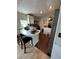 Cozy kitchen featuring white cabinets, stainless steel hood, and a charming breakfast bar with seating for two at 50989 Highway 27 # 210, Davenport, FL 33897