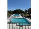 Community swimming pools with ample lounge chairs surrounded by lush trees and landscaping on a sunny day at 50989 Highway 27 # 210, Davenport, FL 33897