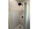 Modern shower with white tiles, black fixtures, and white hexagon tile floor at 50989 Highway 27 # 210, Davenport, FL 33897