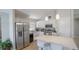 Modern kitchen boasts stainless steel appliances, white cabinets, and a breakfast bar with white countertops at 5275 Warrior Ln, Kissimmee, FL 34746