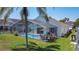 A picturesque backyard featuring a screened pool, covered lanai, patio dining set, and tropical plants at 529 Eagle Pointe N, Kissimmee, FL 34746