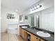 Bathroom with double sinks, a soaking tub, and a separate shower at 529 Eagle Pointe N, Kissimmee, FL 34746