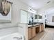 Well-lit bathroom with a dual sink vanity, soaking tub, and open access to the main bedroom at 529 Eagle Pointe N, Kissimmee, FL 34746