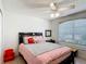 Cozy bedroom with ceiling fan, window with blinds, and a plush bed with colorful accents at 529 Eagle Pointe N, Kissimmee, FL 34746