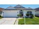 Charming single-story white home featuring a two-car garage and well-manicured lawn at 529 Eagle Pointe N, Kissimmee, FL 34746