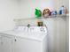 Laundry room with a full sized white washer and dryer, and storage at 529 Eagle Pointe N, Kissimmee, FL 34746