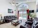 Spacious living room with leather sofas and sliding glass doors to the pool at 529 Eagle Pointe N, Kissimmee, FL 34746