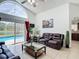 Open-concept living room with high ceilings, pool view, and comfortable leather seating at 529 Eagle Pointe N, Kissimmee, FL 34746