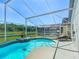 Relaxing enclosed pool area with picturesque water views, lounge chairs, and tropical landscaping at 529 Eagle Pointe N, Kissimmee, FL 34746