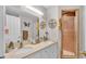 Bathroom with double sinks, white cabinets, and a tiled shower at 6056 Hillside Heights Dr, Lakeland, FL 33812