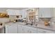 Bright kitchen featuring white cabinets, modern countertops, and a stainless steel sink at 6056 Hillside Heights Dr, Lakeland, FL 33812