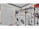Bright laundry room featuring a modern washer and dryer, utility sink, and convenient storage shelves at 6056 Hillside Heights Dr, Lakeland, FL 33812