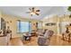 Comfortable living room featuring wood floors, ceiling fan, and bright natural light at 6056 Hillside Heights Dr, Lakeland, FL 33812