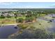 Waterfront aerial view of property with a dock, lush greenery, and lake at 6132 Waterfield Way, St Cloud, FL 34771