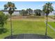 Expansive backyard with lush lawn, palm trees, and water views, perfect for outdoor living at 6132 Waterfield Way, St Cloud, FL 34771
