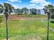 Large backyard view to lake through palm trees at 6132 Waterfield Way, St Cloud, FL 34771