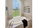 Elegant bathroom with a luxurious soaking tub, modern fixtures, and a serene window view at 6132 Waterfield Way, St Cloud, FL 34771