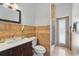 Bathroom featuring tiled floors, a shower with a glass door, a toilet, and a dark wooden sink vanity with a marble countertop at 6132 Waterfield Way, St Cloud, FL 34771