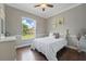 Comfortable bedroom with hardwood floors, a white dresser, and a window overlooking the backyard lawn at 6132 Waterfield Way, St Cloud, FL 34771
