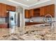 Modern kitchen featuring granite countertops, stainless steel appliances, and wooden cabinets at 6132 Waterfield Way, St Cloud, FL 34771