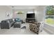 Cozy living room with gray sofa, accent chair, and views of the green outdoors at 6132 Waterfield Way, St Cloud, FL 34771