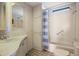 Clean white bathroom features a sink, vanity, medicine cabinet, and a shower-tub combo with blue curtains at 6711 Canterbury Ne Dr, Winter Haven, FL 33881
