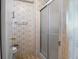 Small guest bathroom with patterned wallpaper and a glass enclosed shower at 6711 Canterbury Ne Dr, Winter Haven, FL 33881
