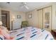 Well lit bedroom with wood look floors, closet, and a decorative green chair at 6711 Canterbury Ne Dr, Winter Haven, FL 33881