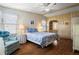 Cozy bedroom features a comfortable bed, side tables with lamps, ceiling fan and wood-look laminate flooring at 6711 Canterbury Ne Dr, Winter Haven, FL 33881
